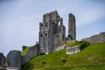View of corfe castle ruins on purbeck hills surrounded by grass, Wareham, United Kingdom.
