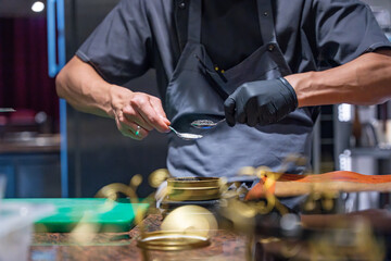 Vue sur un chef cuisinier qui prépare des portions de caviar.