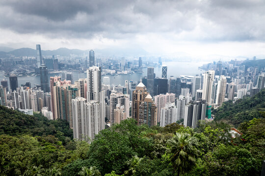 View of breathtaking skyline with modern skyscrapers and lush green forests against the backdrop of mountains, Central, Hong Kong.