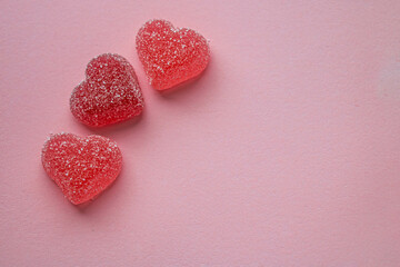 Obraz premium Three gummy hearts on a pink background with space for an inscription