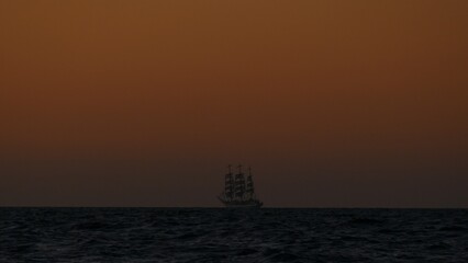 background - tall ship in the ocean after sunset