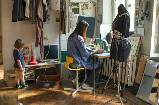
a woman artist with her son works in her local shop