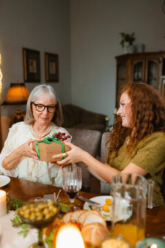 A woman gives a gift to her mother