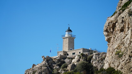 The **Melagavi Lighthouse** is located near Loutraki, in Corinthia. It was built in 1897 and stands about 18 meters tall. It is a stone-built, cylindrical lighthouse with a white color and a red top. 