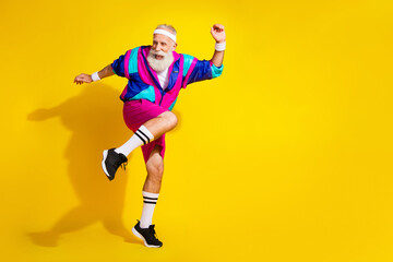 Full length photo of handsome good mood senior guy oldschool sportswear dancing emtpy space isolated yellow color background