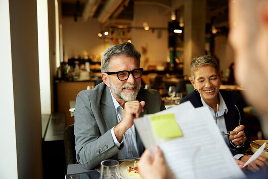 Businesspeople work and enjoy lunch