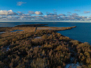 Obraz premium Stunning aerial view of Paljassaare Peninsula in Tallinn, Estonia. Vast coastal landscapes, serene wetlands, and the Baltic Sea meet under a vibrant blue sky. Perfect for nature and travel concept