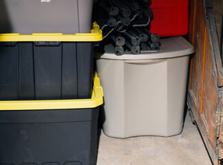 Plastic storage bins stacked in dusty basement cellar
