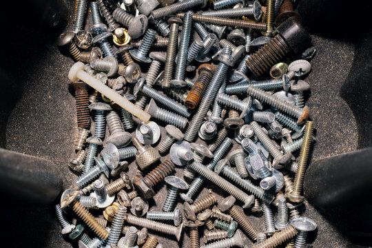 Close up of pile of assorted dusty screws