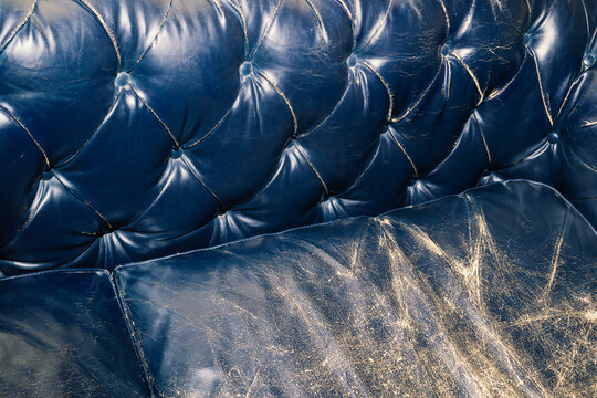 Flash photograph of faded navy blue leather couch