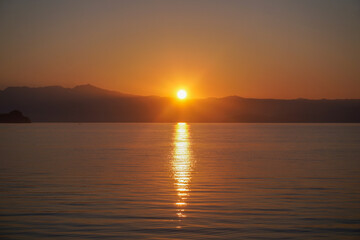 Amanecer en la Laguna de Catemaco con reflejo dorado sobre el agua