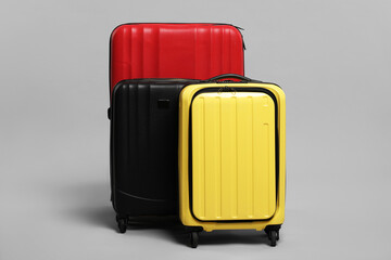 Many closed colorful suitcases on grey background