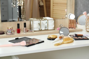 Makeup room. Different beauty products on white dressing table and mirror indoors