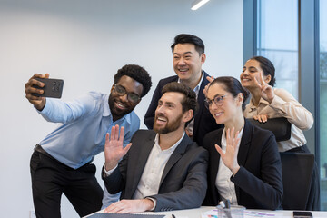 Successful diverse business team, men and women talking in the middle of the office, taking selfie...
