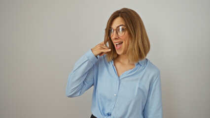 Woman posing isolated on white background making a phone gesture with her hand while smiling...