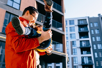 Father play with toddler daughter. Street view of vibrant city. Concept of parenting, father-child bond, outdoor fun, happiness, and joy with a playful and caring touch in urban environment.