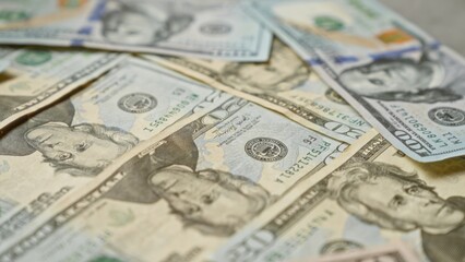 United states dollar banknotes scattered, highlighting various denominations with intricate details, symbolizing wealth and financial concepts.