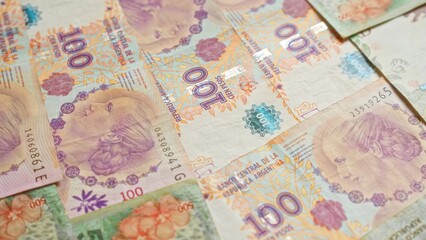 Argentinian banknotes scattered across a surface showcasing various denominations of pesos, highlighting the intricate designs and vibrant colors of argentina's currency.