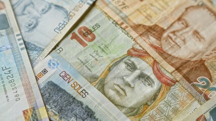 Peruvian banknotes depicting various denominations of soles displayed closely, showcasing intricate designs and details, symbolizing the vibrant currency of peru.