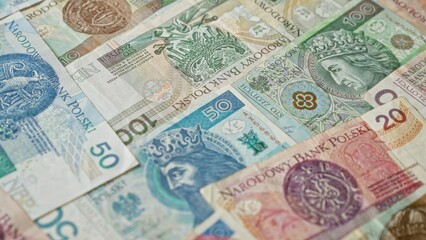 Polish zloty banknotes of various denominations spread out showcasing currency from poland's...