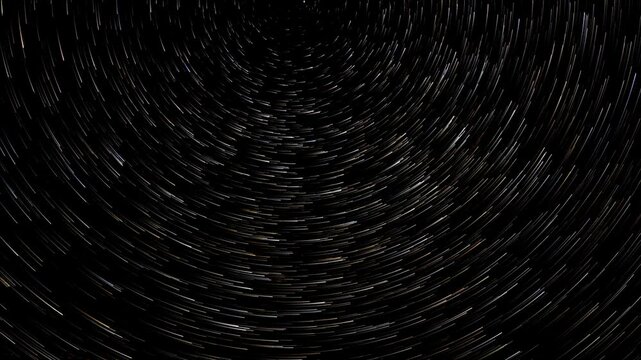 Time lapse of stars moving through the night sky leaving comet like trails
