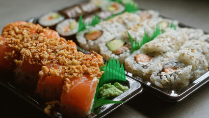 Delicious sushi tray with assorted rolls and garnishes showcasing fresh seafood in bento boxes