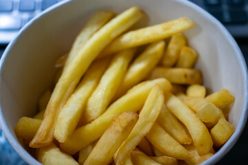 Freshly cooked golden fries served in a bowl, perfect for snacking or pairing with a meal