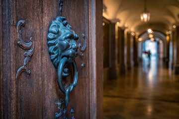 T&uuml;r mit einem T&uuml;rklopfer vor einer Passage