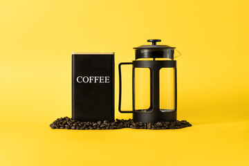 French press with one container for coffee, coffee, and sugar on a yellow background