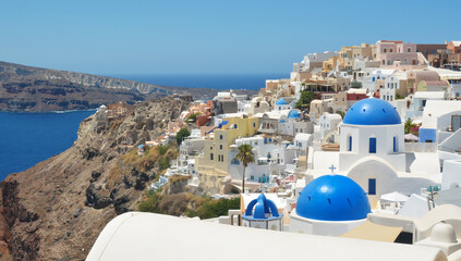 Oia village on Santorini island, Greece. Traditional and famous houses and churches with blue domes...