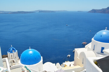 Oia village on Santorini island, Greece. Traditional and famous houses and churches with blue domes...