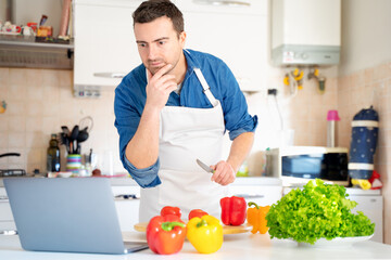 One man is learning to cook watching video online