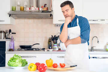 Doubtful man looking for inspiration to cook vegetables food