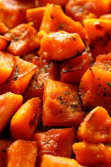 Sliced on cube ​​roasted pumpkin, focus on the center. Pumpkin background