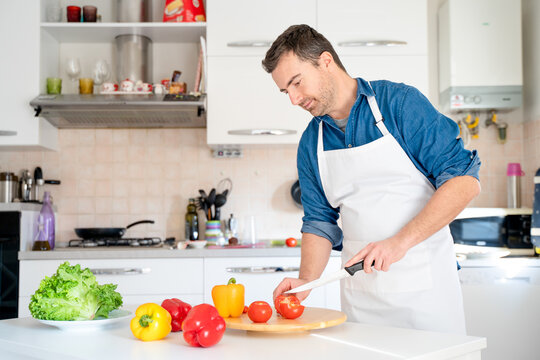 Man cutting some vegetables and cooking at home