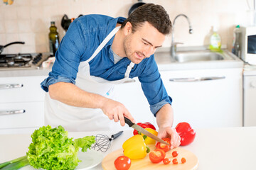 Portrait of one man cooking at home cutting vegetables
