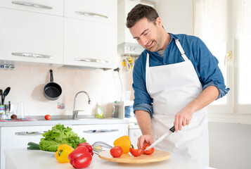 Portrait of one man cooking at home cutting vegetables