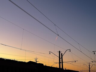 Flying airplane at the sunset, the train station