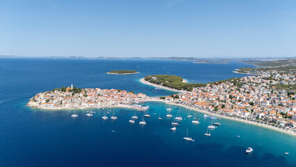 Primosten Town, Adriatic Sea, Croatia. Idyllic Beach on Mediterranean Sea Coast Near Medieval Primosten City in Croatia. Summer Holidays Travel Destination. Blue Sky, Azure Water.