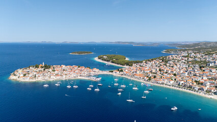 Primosten Town, Adriatic Sea, Croatia. Idyllic Beach on Mediterranean Sea Coast Near Medieval Primosten City in Croatia. Summer Holidays Travel Destination. Blue Sky, Azure Water.