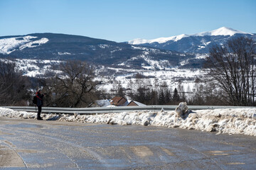The photographer moves along the mountain road and photographs the nature around him. Winter landscape of the surroundings. Vlasina Lake, Serbia.

