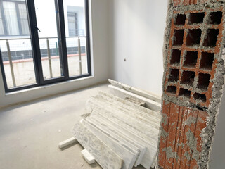 Brick Wall and Marble Slabs in Construction Area. Exposed brick wall section with rough edges...