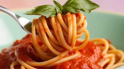 A fork twirling a delicious portion of spaghetti topped with rich tomato sauce, garnished with fresh basil leaves.
