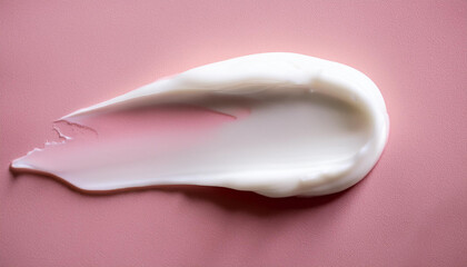 White cosmetic cream smear on pastel pink surface. Creamy texture. Skin care, beauty product