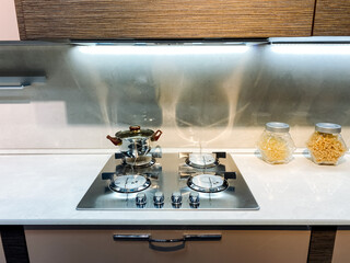 Imagine a beautifully designed kitchen that features a gas stove top oven, complemented by jars filled with various types of pasta, proudly displayed on the countertop for quick access