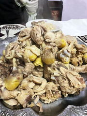 Steaming pile of boiled chicken pieces. Freshly boiled chicken served on a metal platter, emitting steam and ready for a hearty meal.