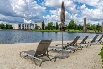 A picturesque place to relax in the park area by the lake. Sandy beach with sun beds and .umbrellas.