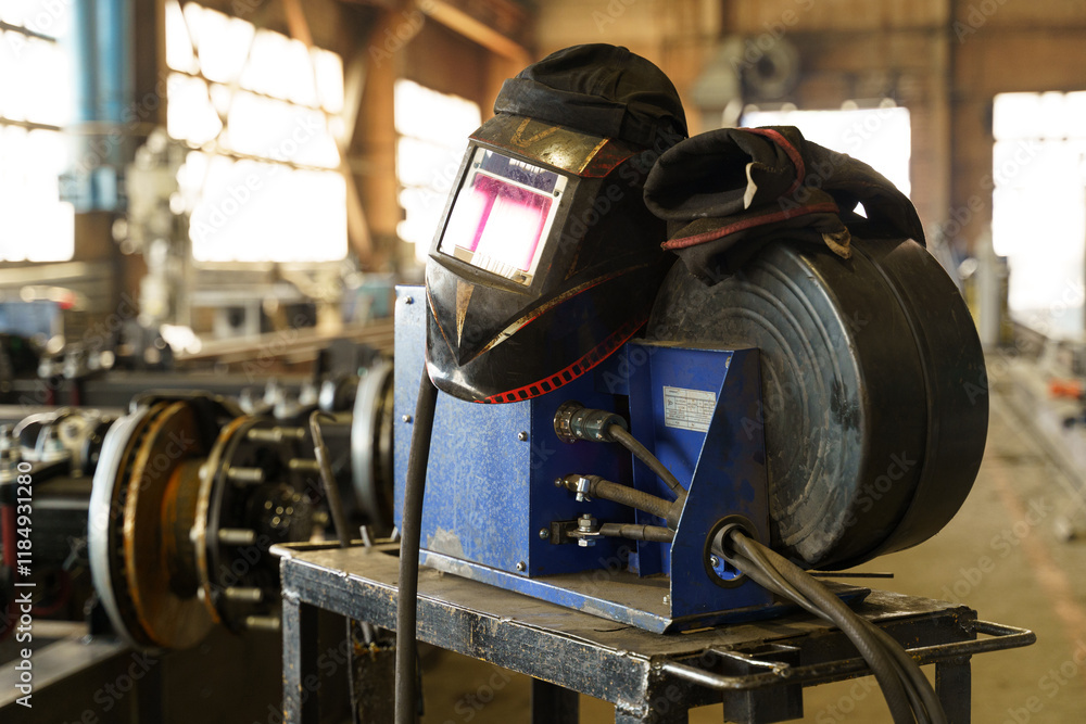 Poster welding equipment on a workshop table in a busy industrial setting