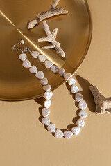 Natural mother-of-pearl necklace. Beads in the shape of hearts. Necklace and marine corals on...