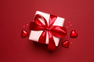 Beautiful gift box with hearts on color background